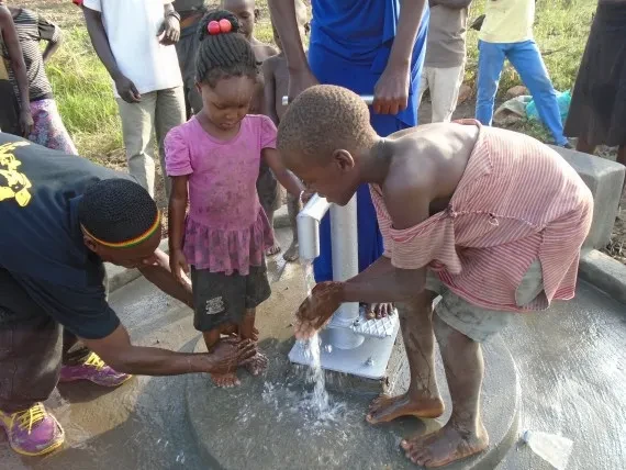 People in Uganda using a clean water pump.