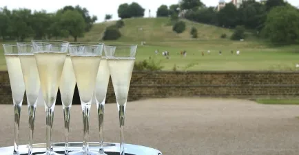 A tray of sparkling drinks with the Royal Observatory Greenwich in the background.