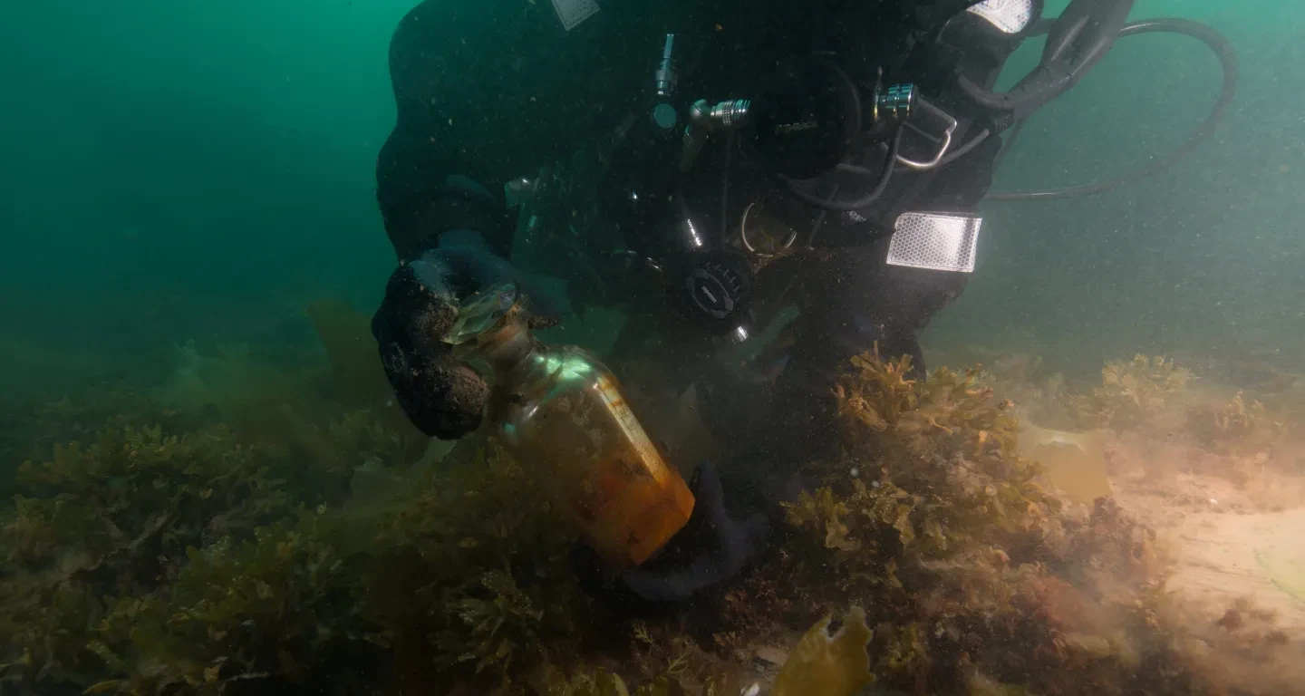A diver examines wreckage on the sea bed.